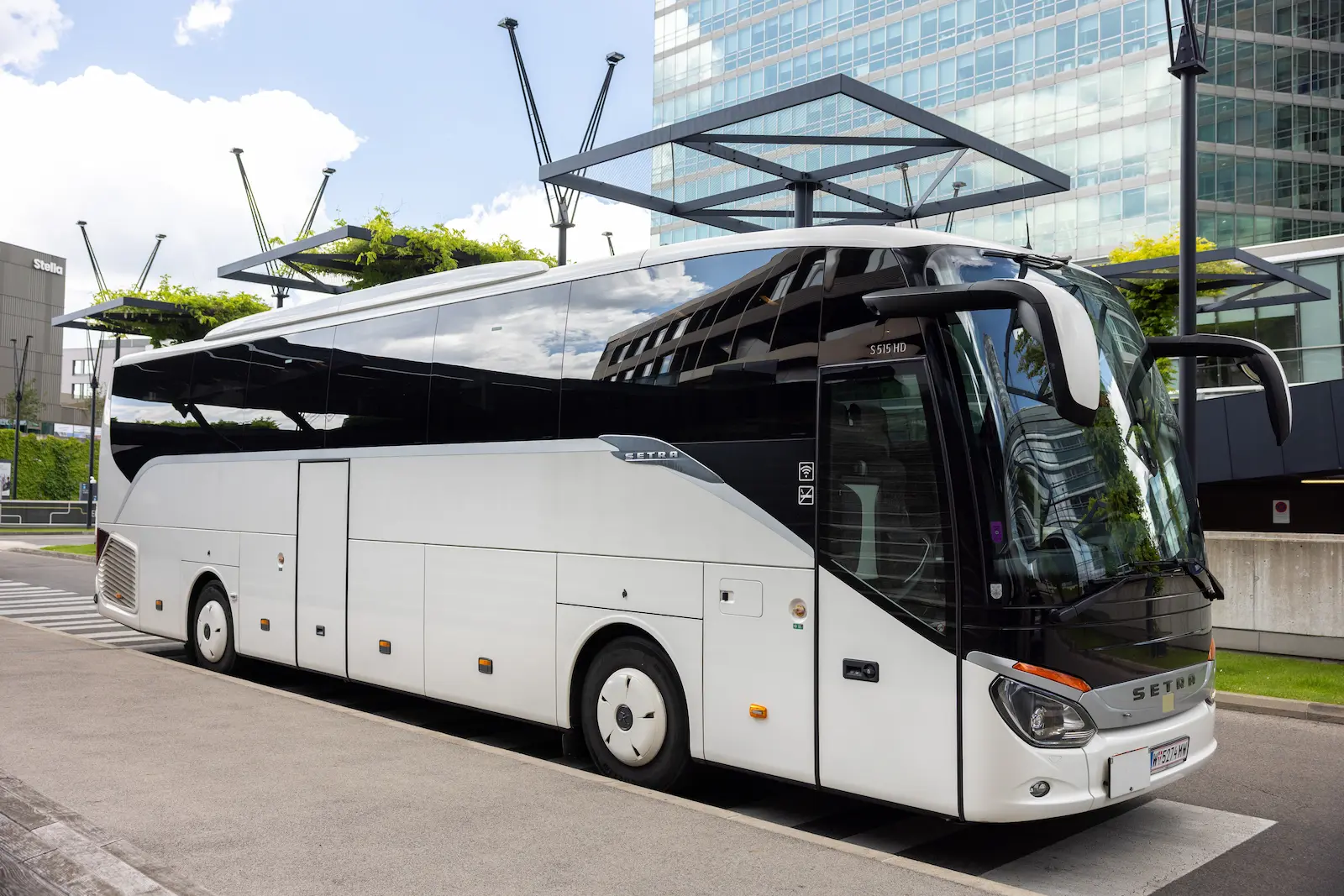 : Ein eleganter VIP Shuttle Service Wien Van parkt vor einem modernen Flughafengebäude, bereit für luxuriöse Gästeanreisen.