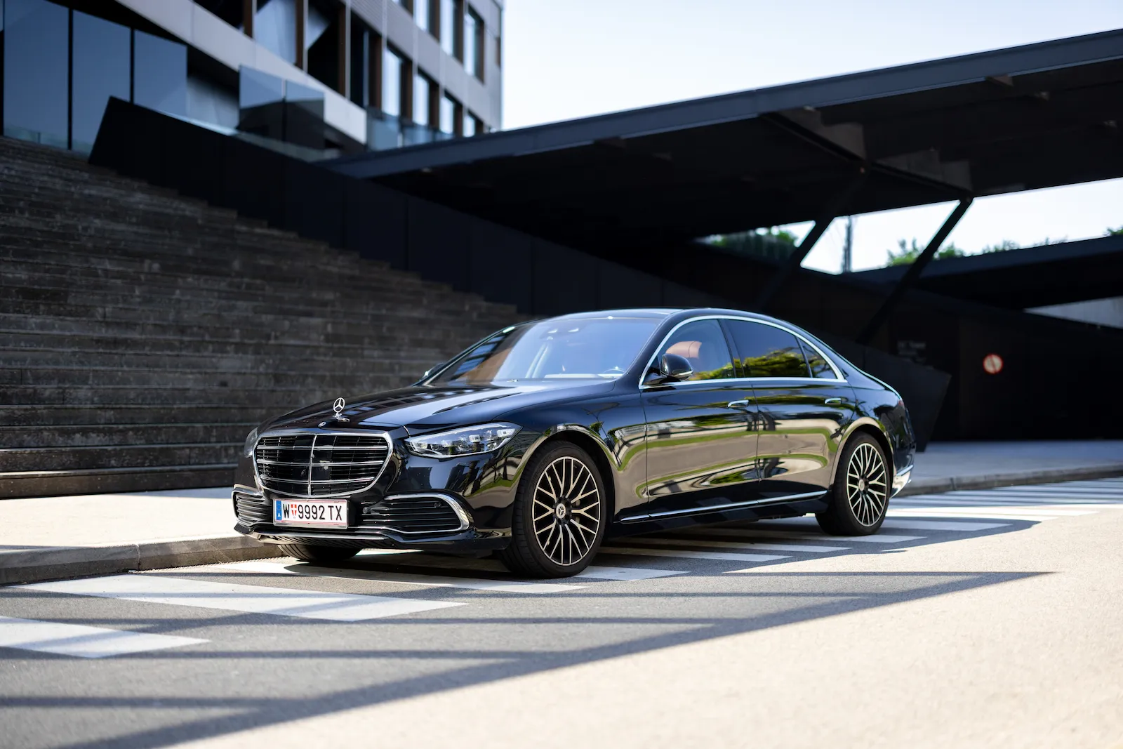 Mercedes S Class Front View Slide mit elegantem Design, geparkt vor modernen Stufen, ideal für Luxusfahrzeuge.