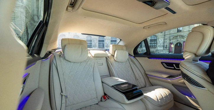 Der luxuriöse MB S Class Inside View Slider mit cremefarbenen Ledersitzen und blauer Ambientbeleuchtung im Innenraum.